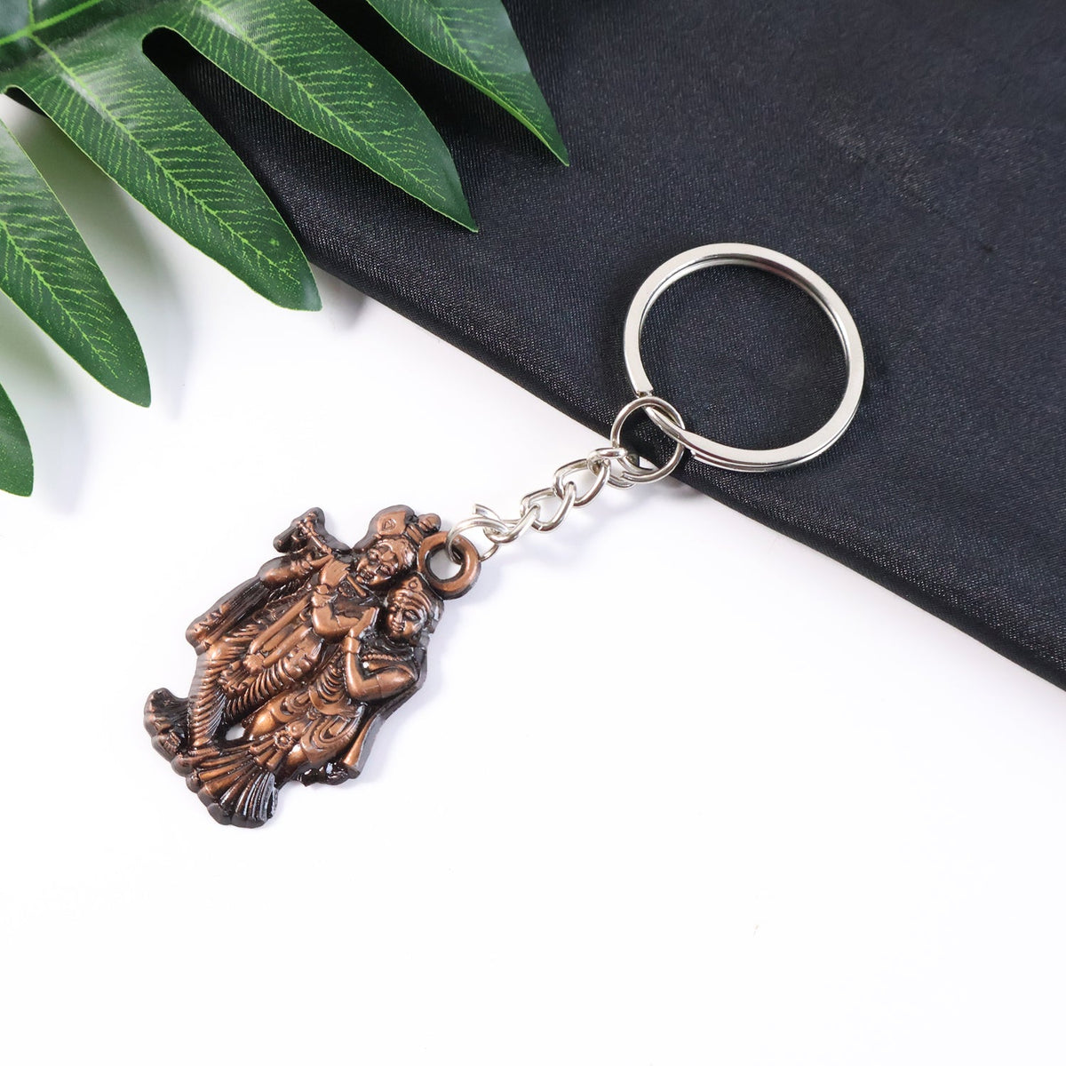 Radha Krishna metal keychain attached to a set of keys symbolizing faith and function