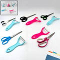 Stainless steel kitchen scissor and vegetable peeler set on a clean surface.