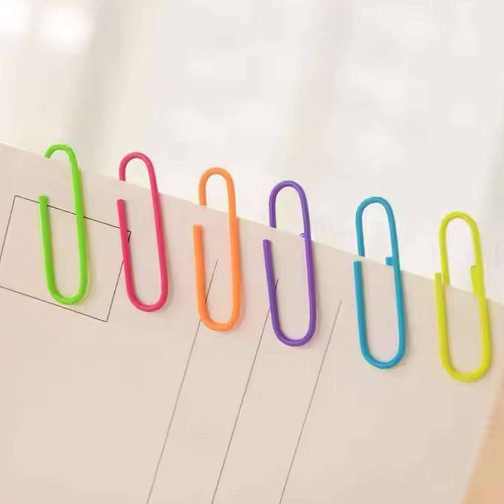 Assorted colored U-shape paper clips 28mm scattered on white background