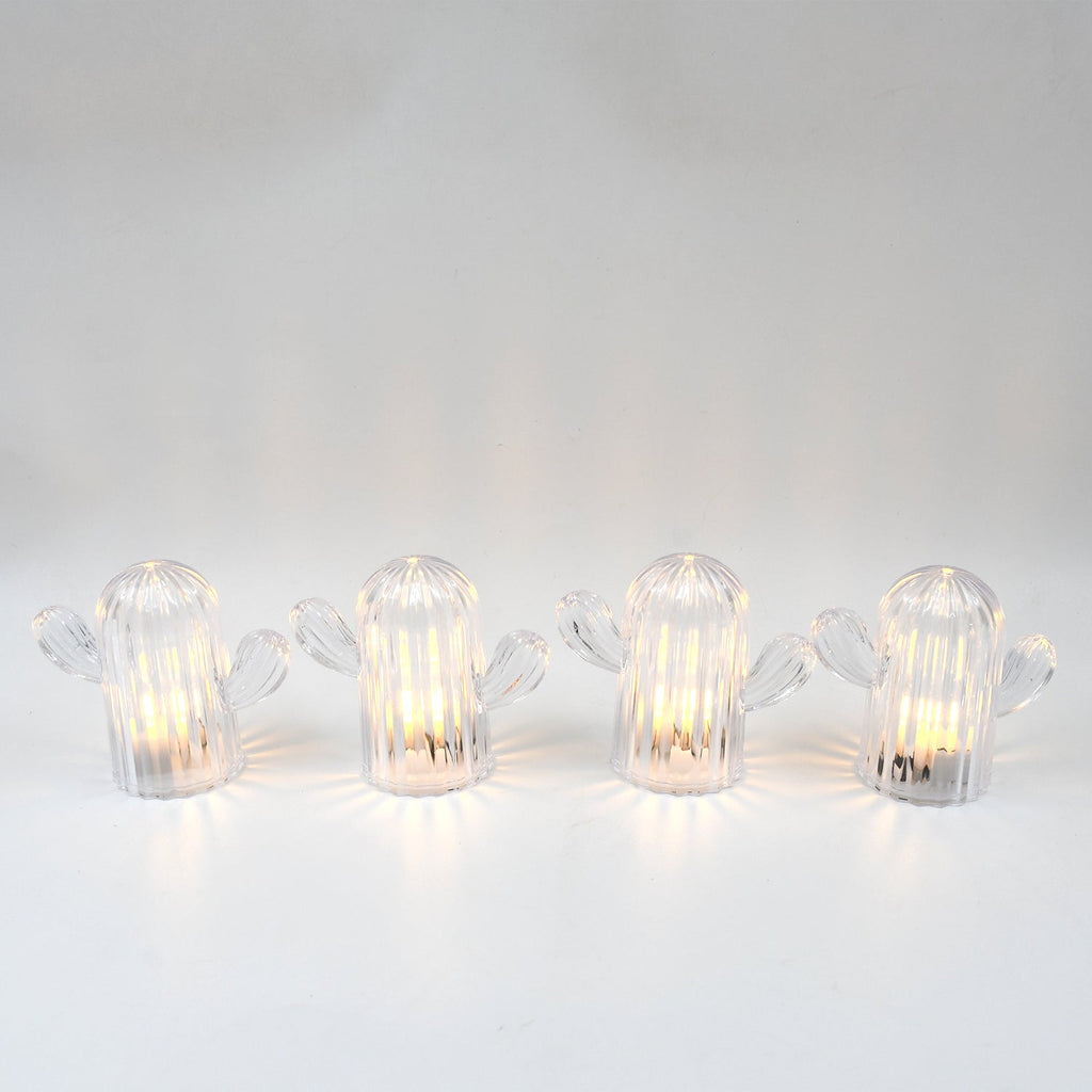 A hand holding a glowing cactus night light, demonstrating its portable and lightweight design.