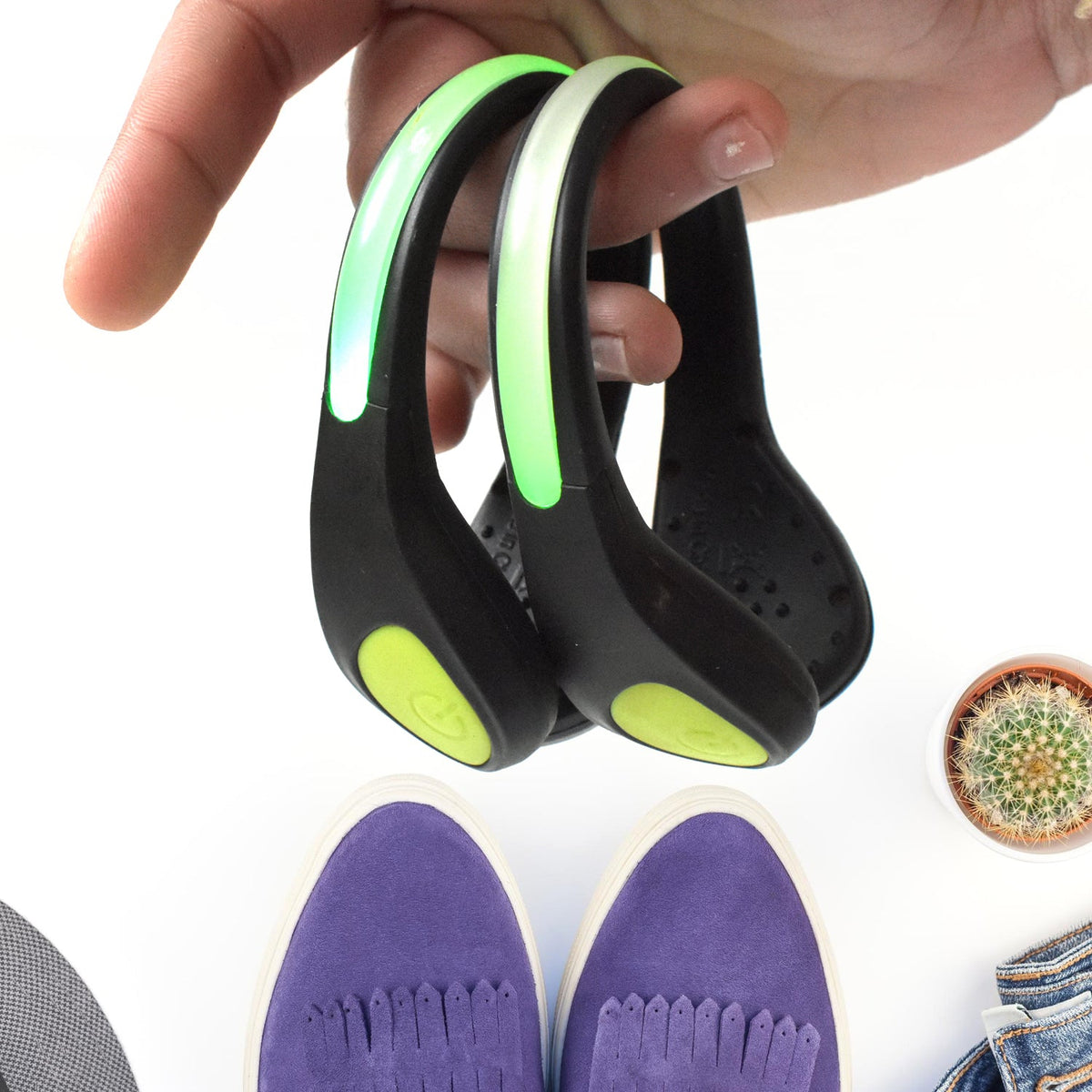 Person jogging at dusk, their shoes lit by bright LED safety clip lights.